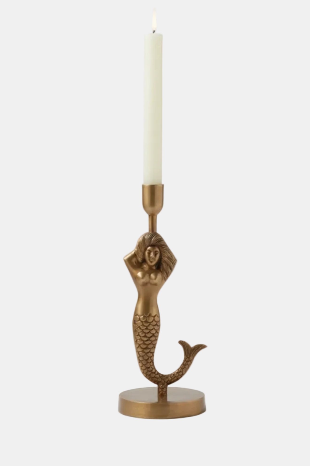 Mermaid-shaped candle holder with a lit candle on a white background