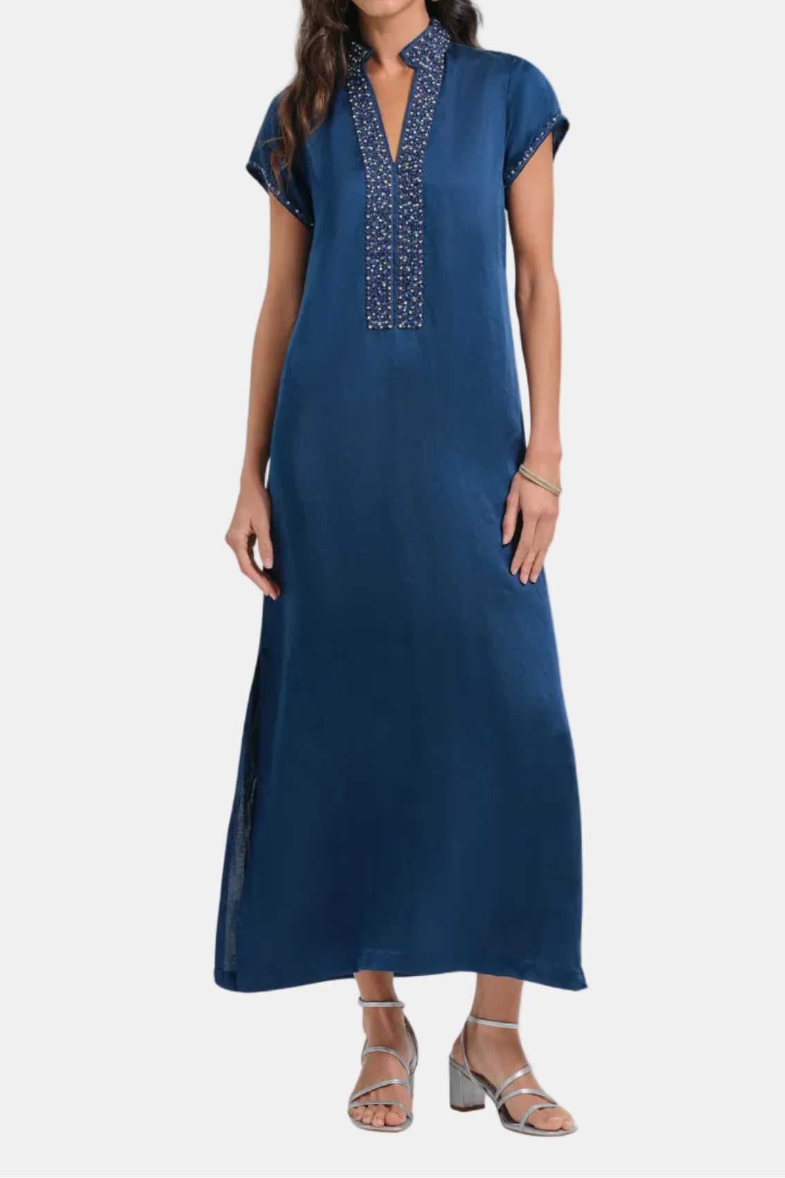 Woman wearing a blue dress with intricate detailing on a white background