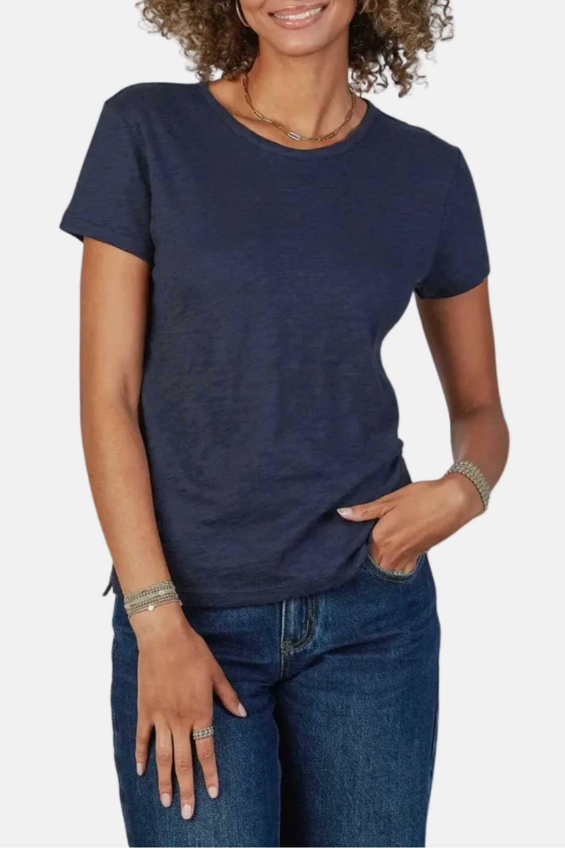 Woman wearing a navy blue t-shirt and jeans on a white background
