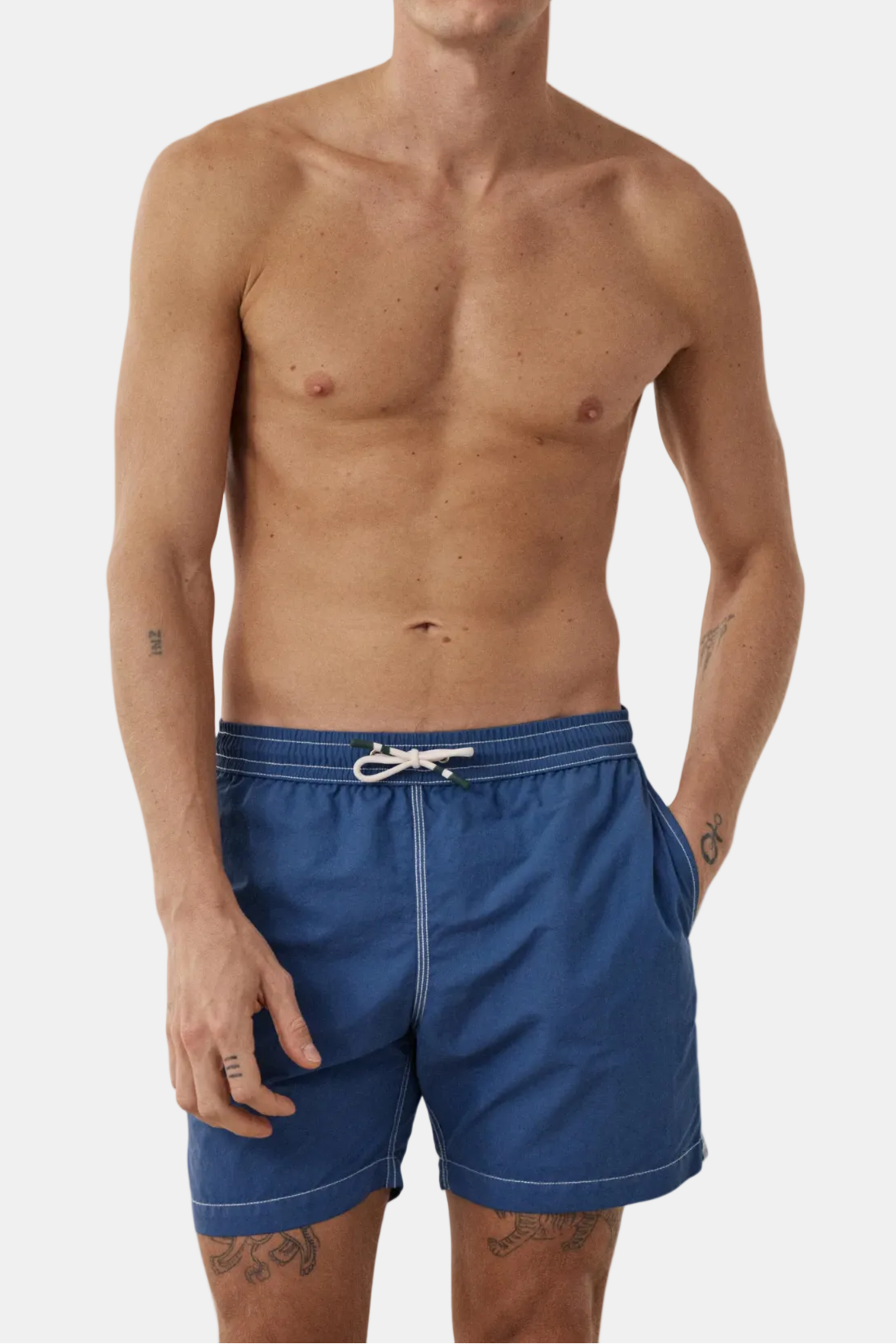 Man wearing blue swim shorts on a white background