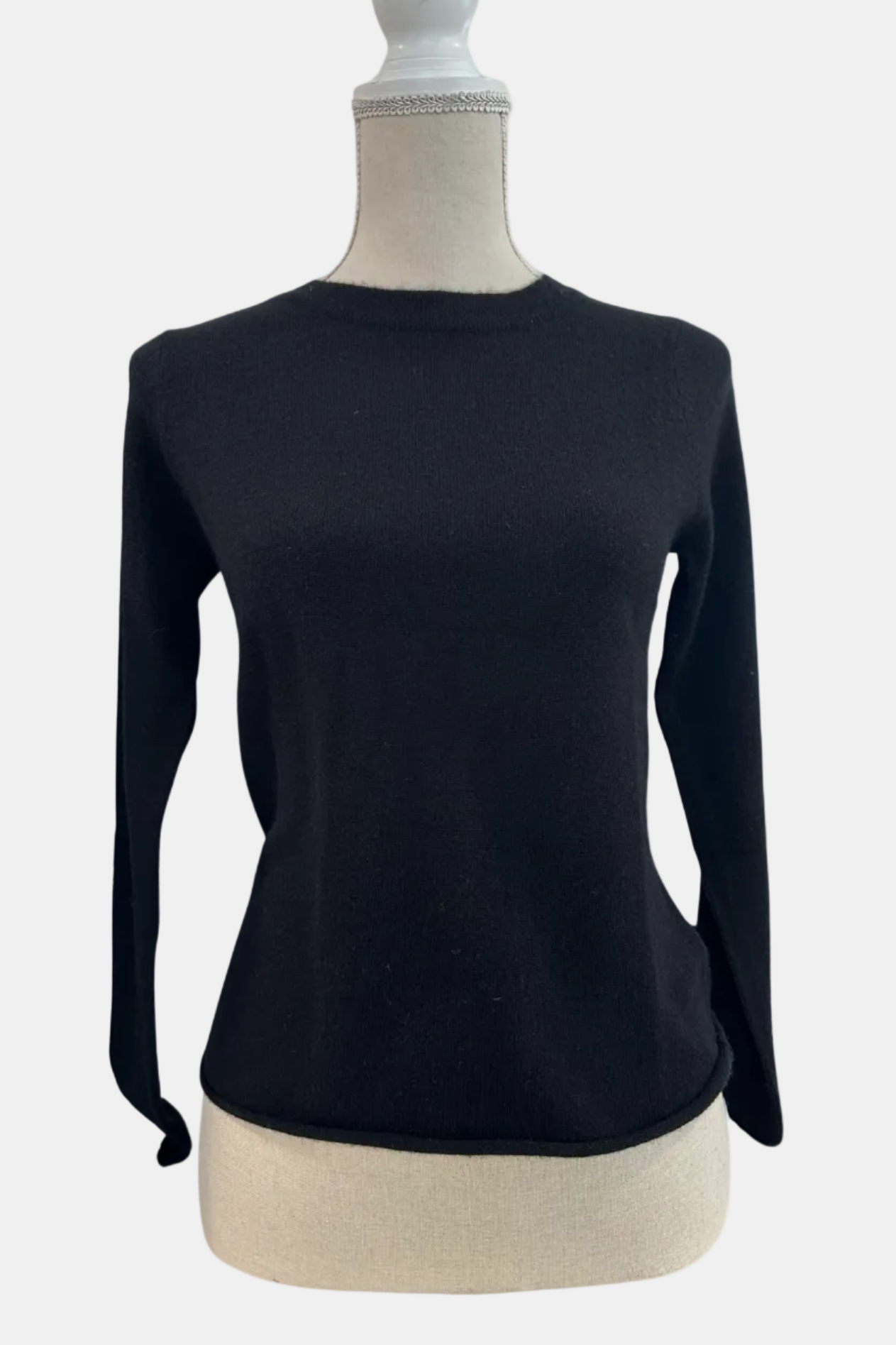 Black long-sleeve top on a mannequin with a white background