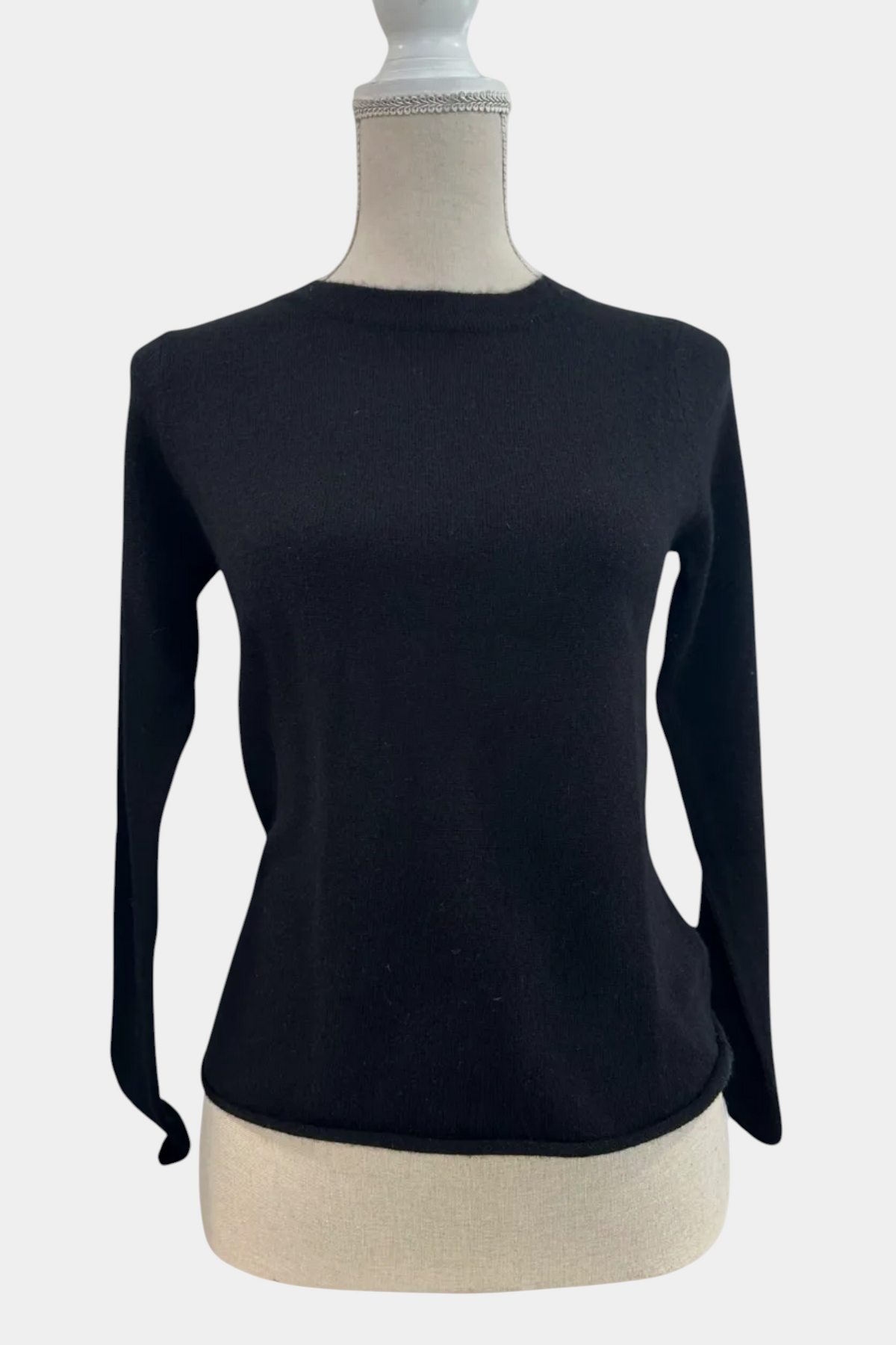 Black long-sleeve top on a mannequin with a white background