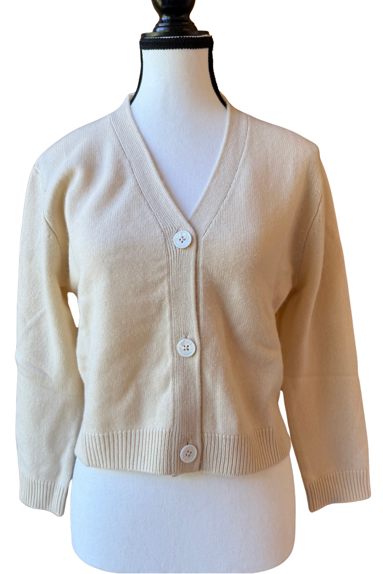 Beige cardigan on a mannequin against a white background