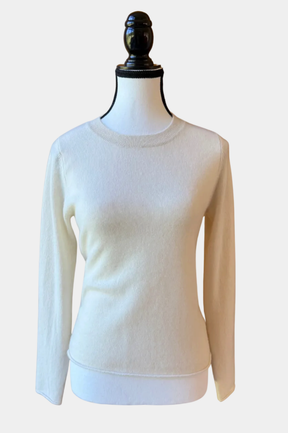 White sweater on a mannequin against a white background