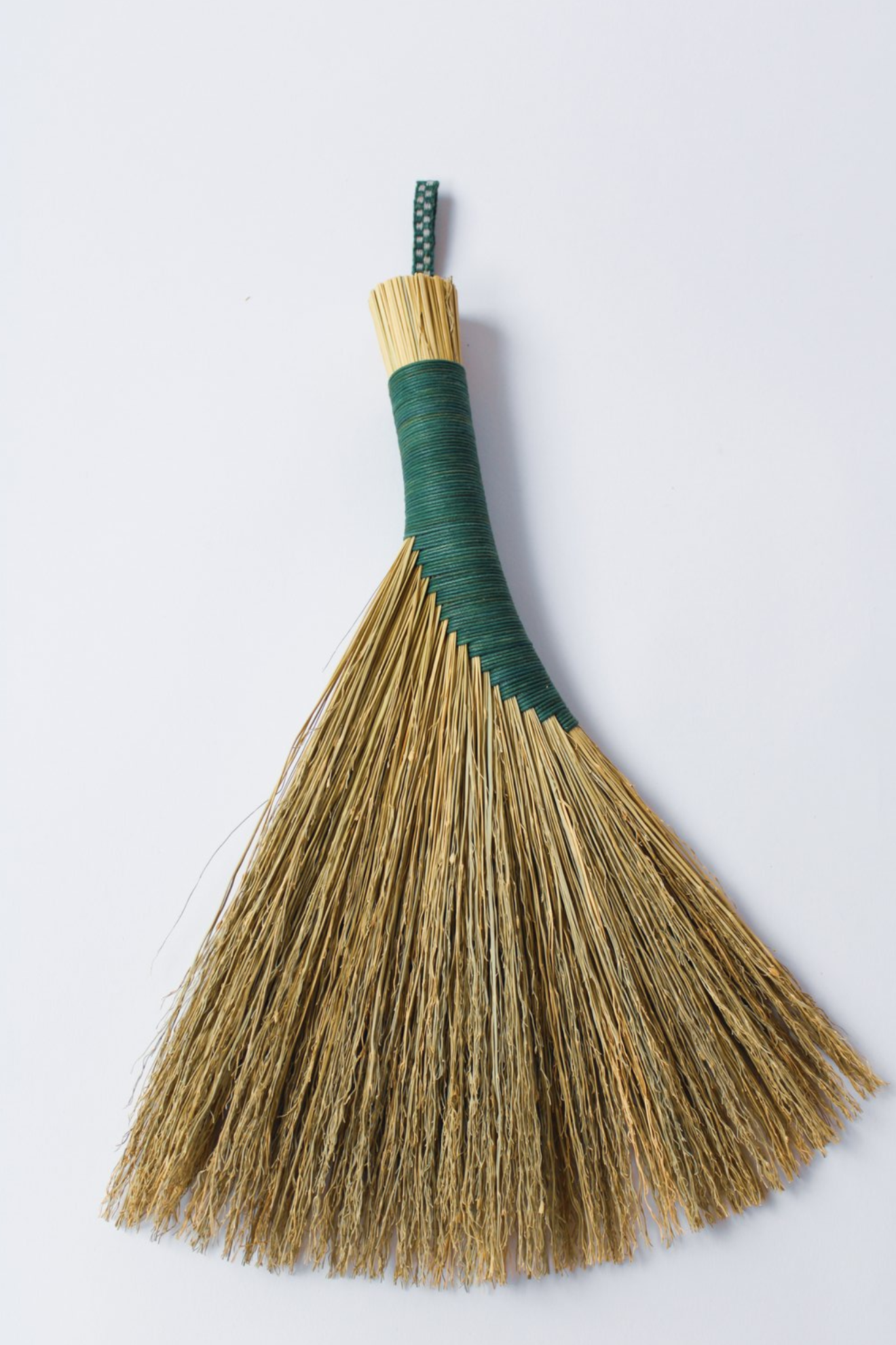 Broom with a green handle on a white background
