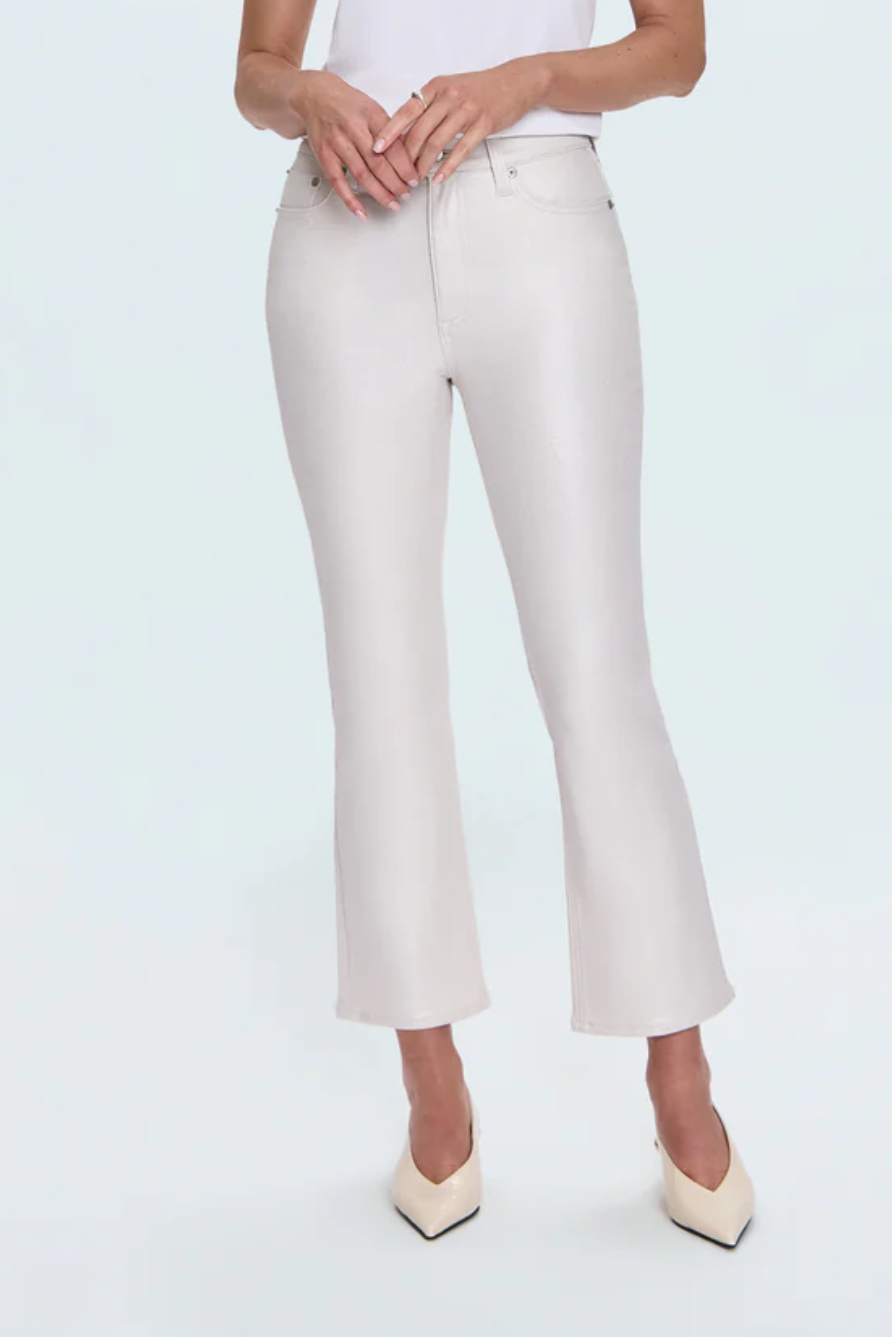 Woman wearing a white t-shirt and white pants on a light blue background