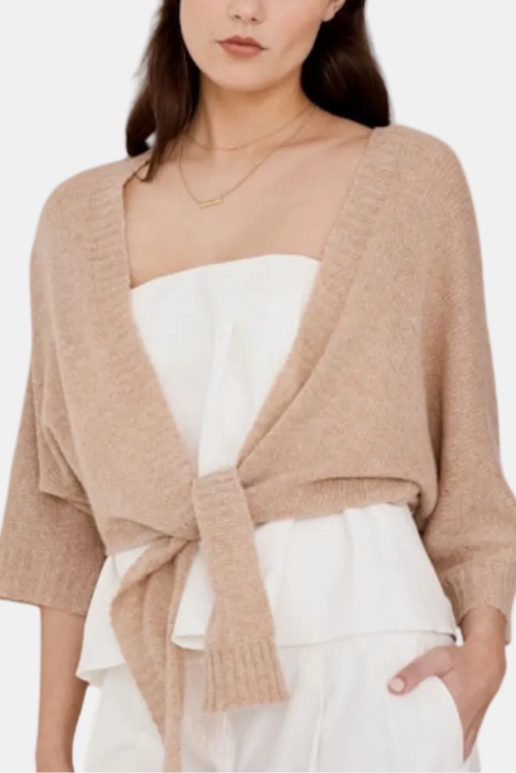 Woman wearing a beige cardigan over a white top on a white background