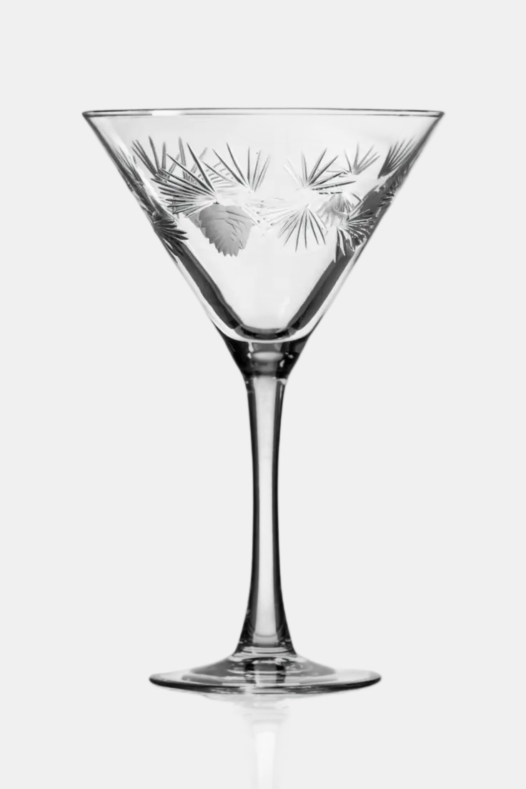 Clear martini glass with intricate etching on a white background
