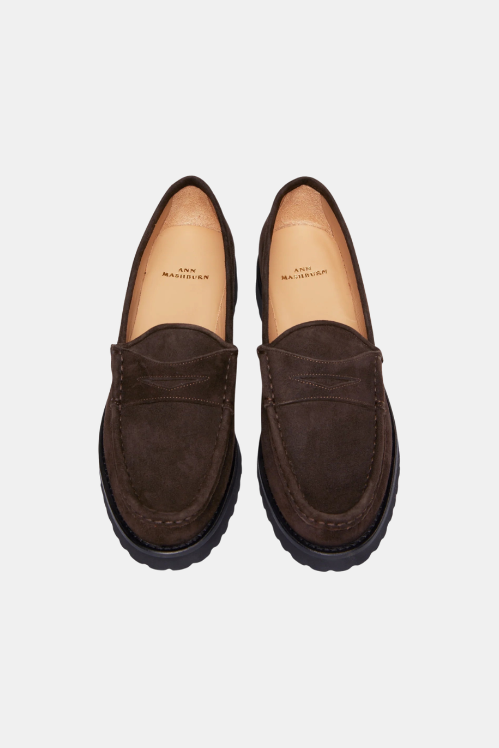 A pair of dark brown suede penny loafers with black soles, shown from a top-down view on a light gray background.