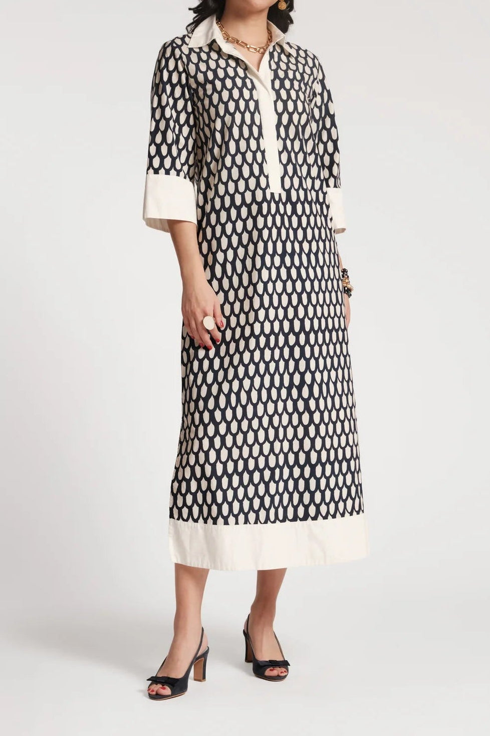 Woman wearing a black and white patterned dress on a white background