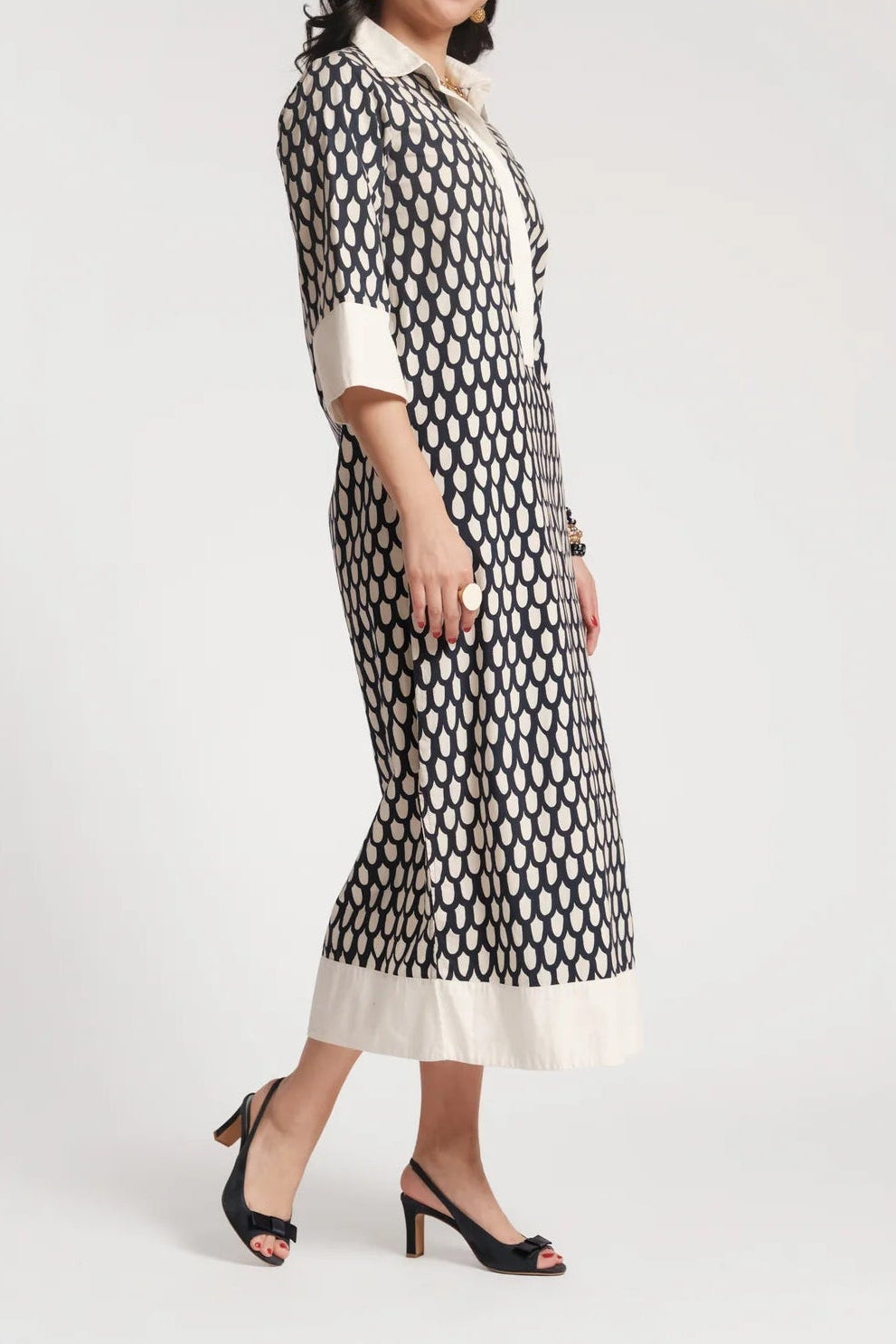 Woman wearing a black and white patterned dress on a light gray background