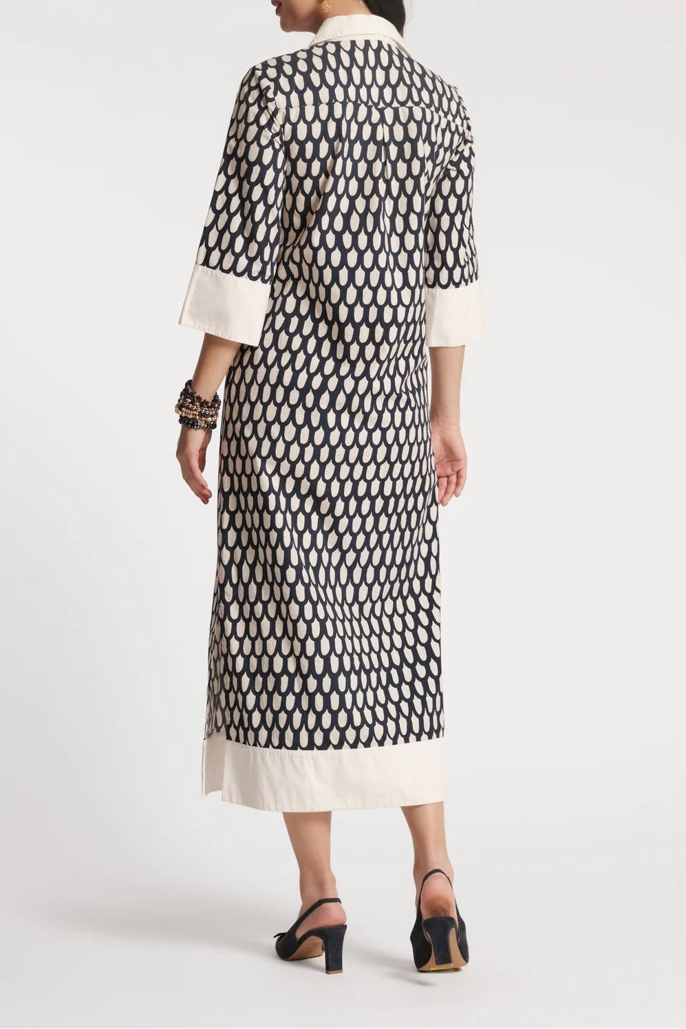 Woman wearing a black and white patterned dress on a white background