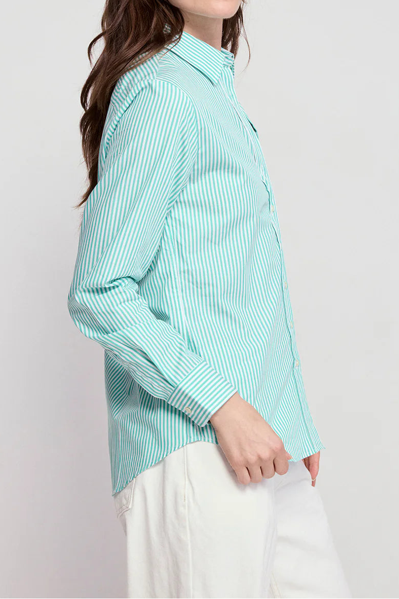 Woman wearing a light blue striped shirt against a white background