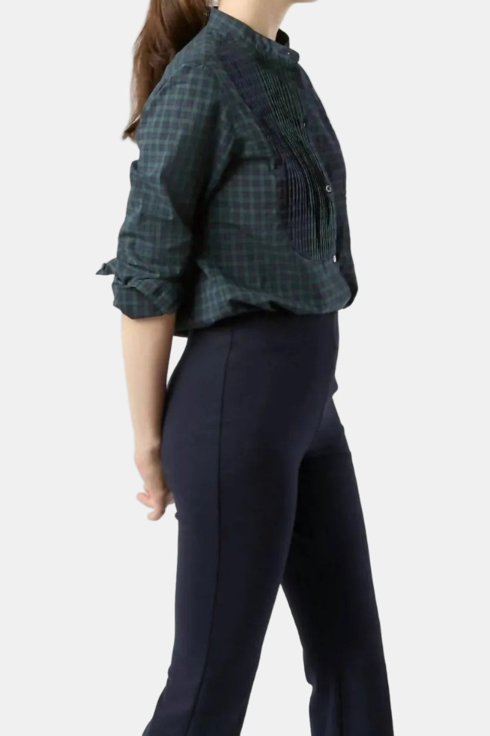 Person wearing a plaid shirt and dark pants on a white background
