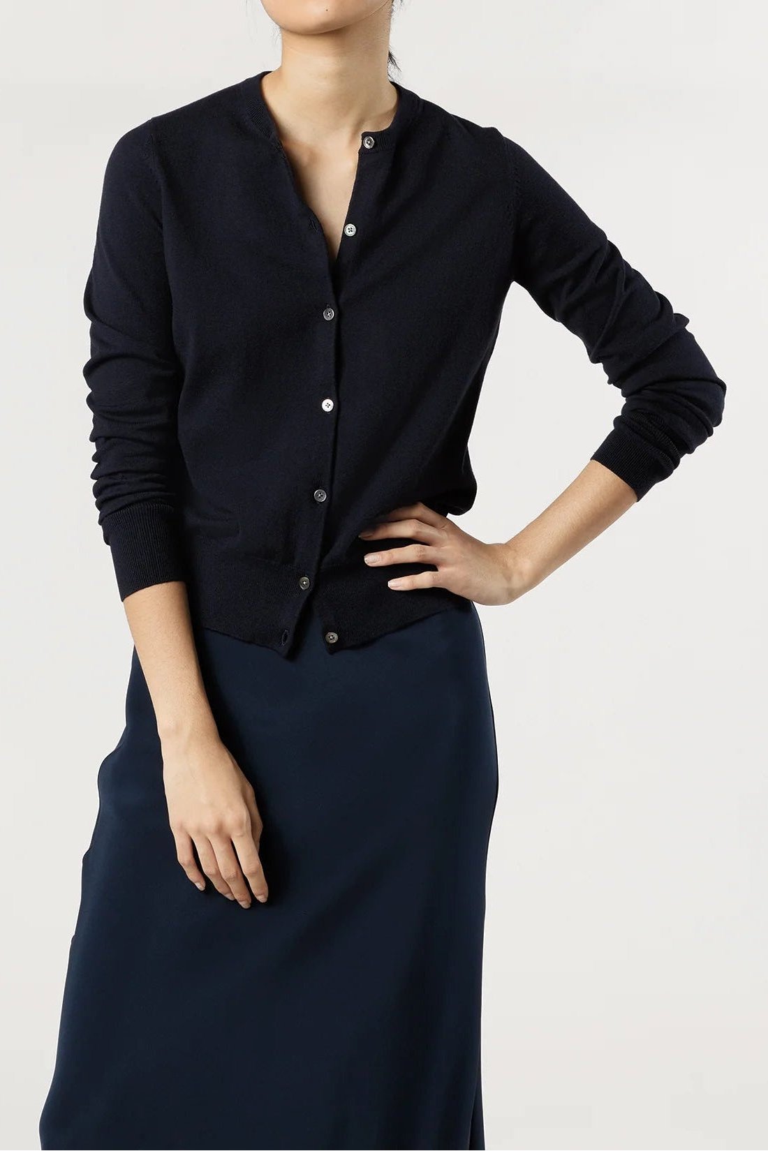 Woman wearing a black cardigan and skirt on a white background