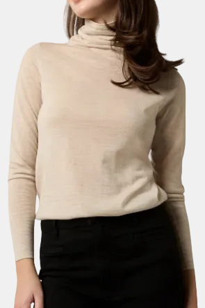 A woman wearing a beige funnel-neck sweater.