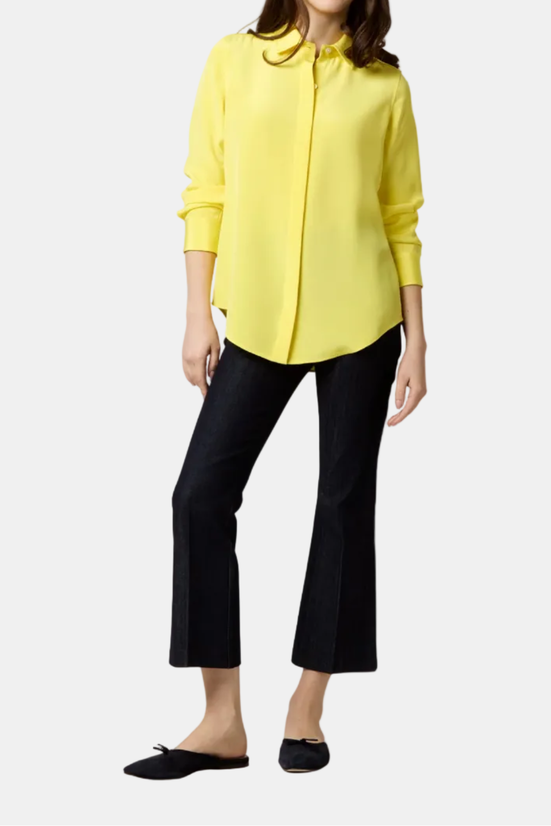 Woman wearing a yellow blouse and black pants on a white background