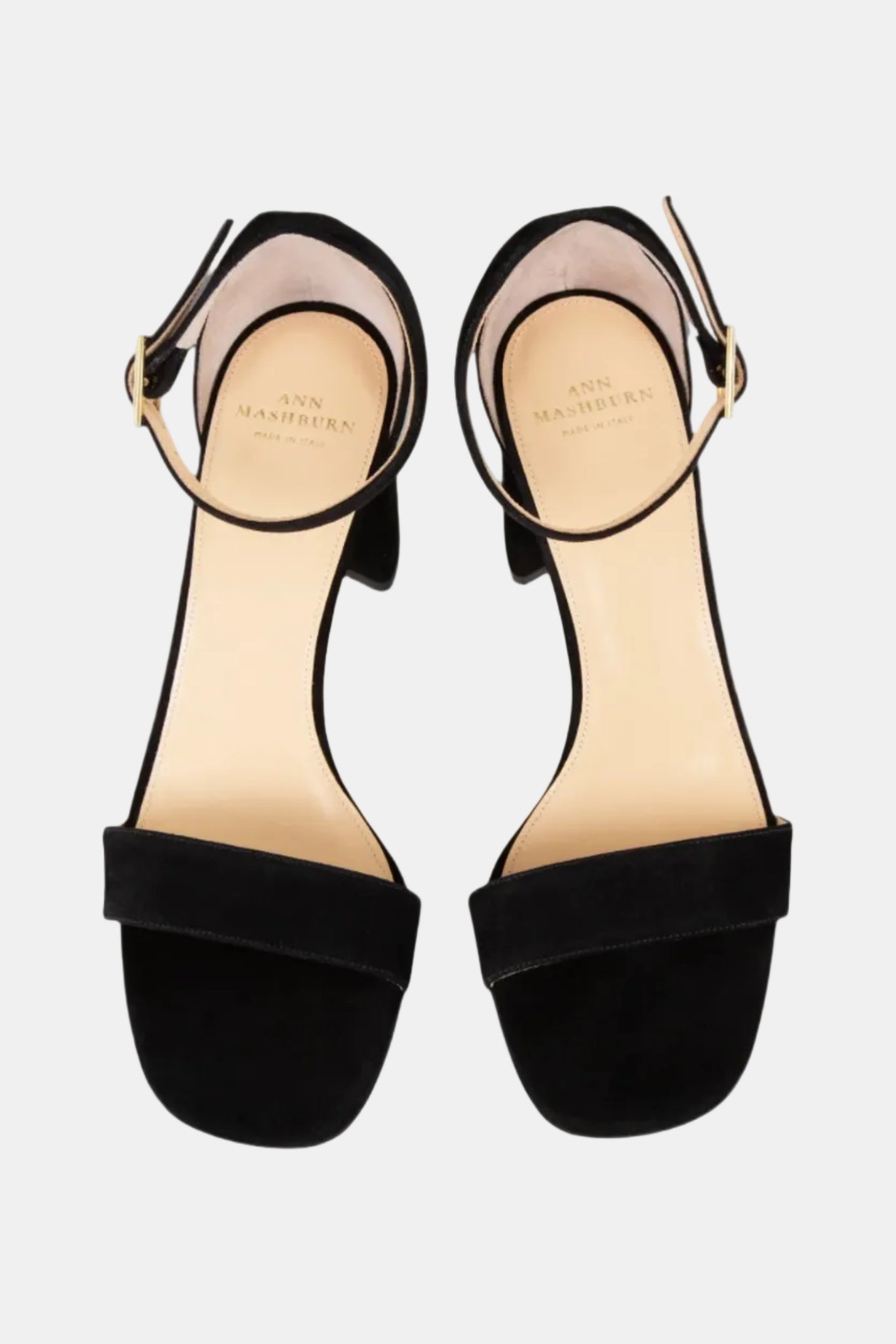Black sandals with thin straps on a light gray background