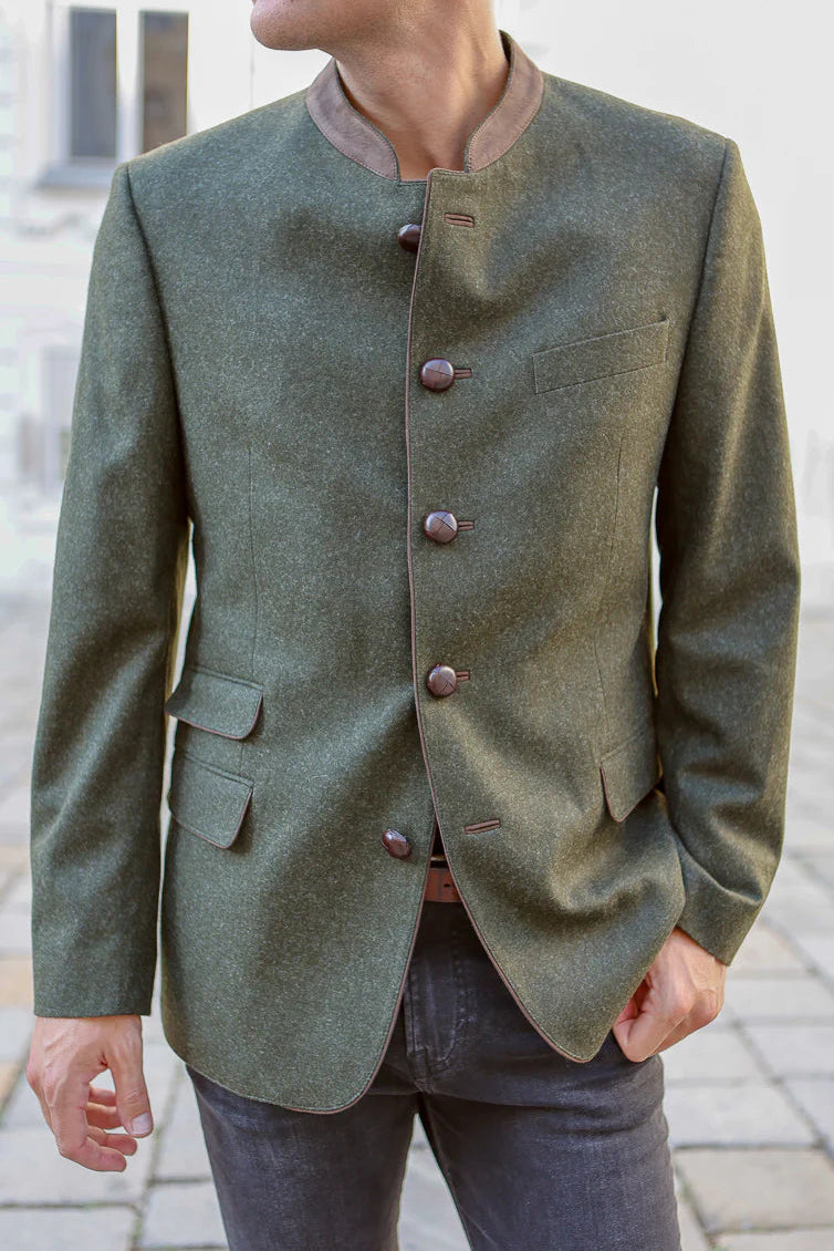 Person wearing a green blazer with brown buttons on a blurred background