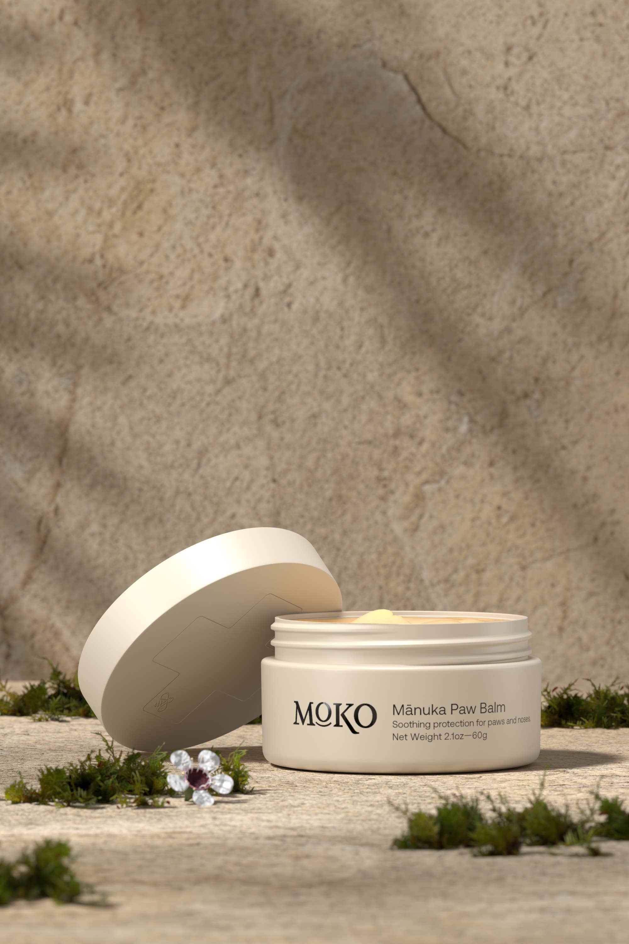 MOKO Manuka Paw Balm jar with lid open on a stone surface with a natural background