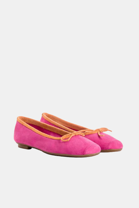 Pair of pink flats with orange laces on a white background