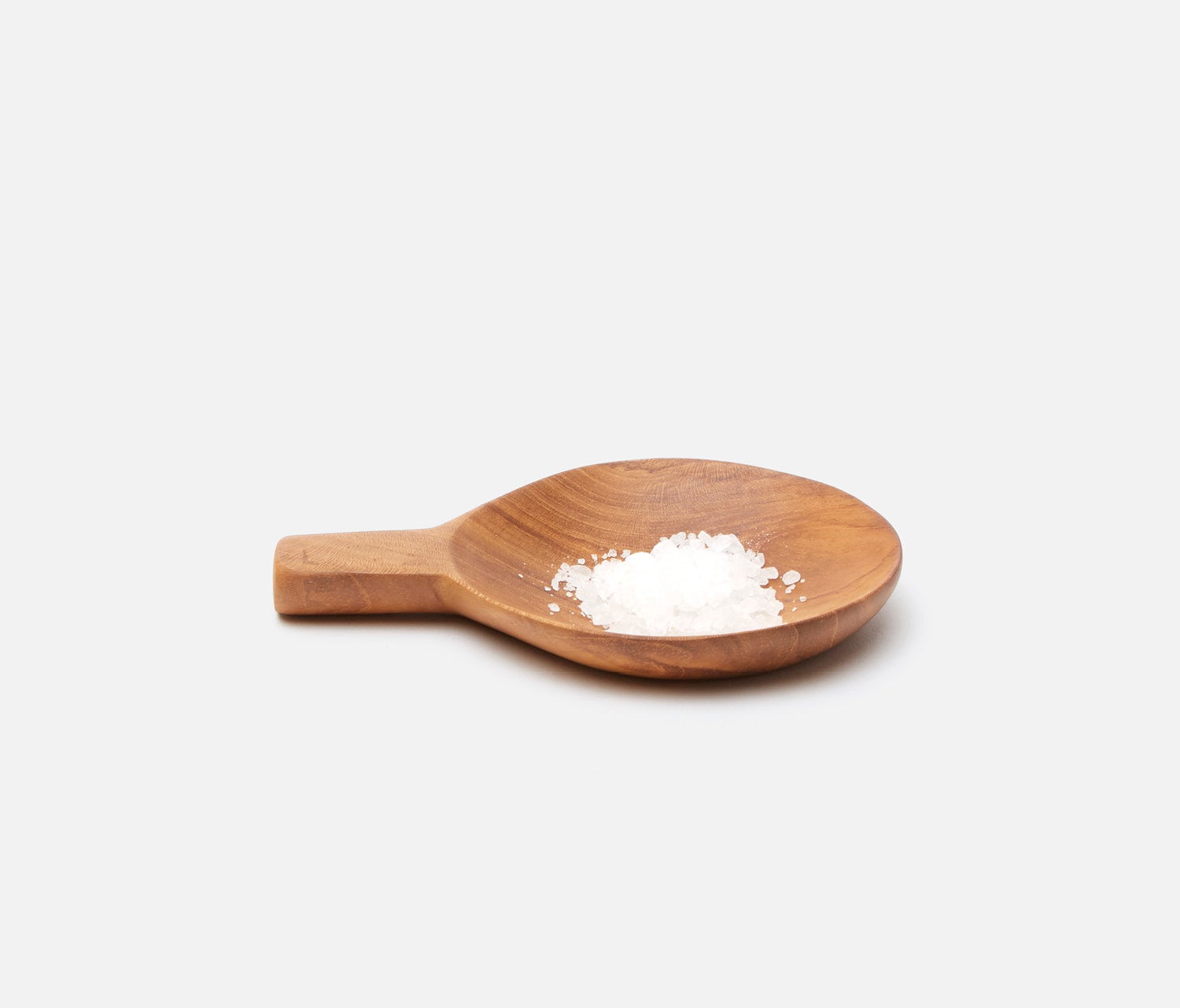 A small wooden spoon with a handle, containing a small pile of white powder, set against a solid light gray background.