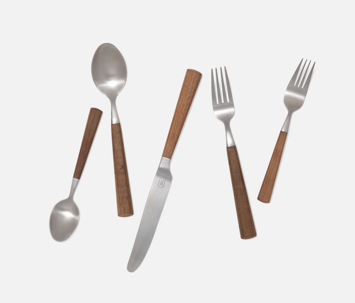 Five-piece stainless steel cutlery set with brown wooden handles, including a spoon, dinner fork, salad fork, knife, and teaspoon, arranged diagonally on a light gray background.