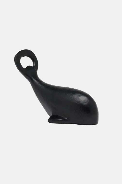 Black bottle opener shaped like a whale on a white background