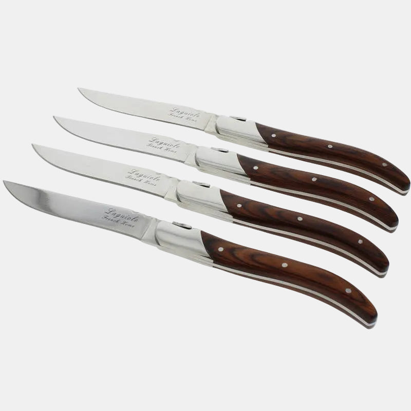 Set of four steak knives with wooden handles on a white background