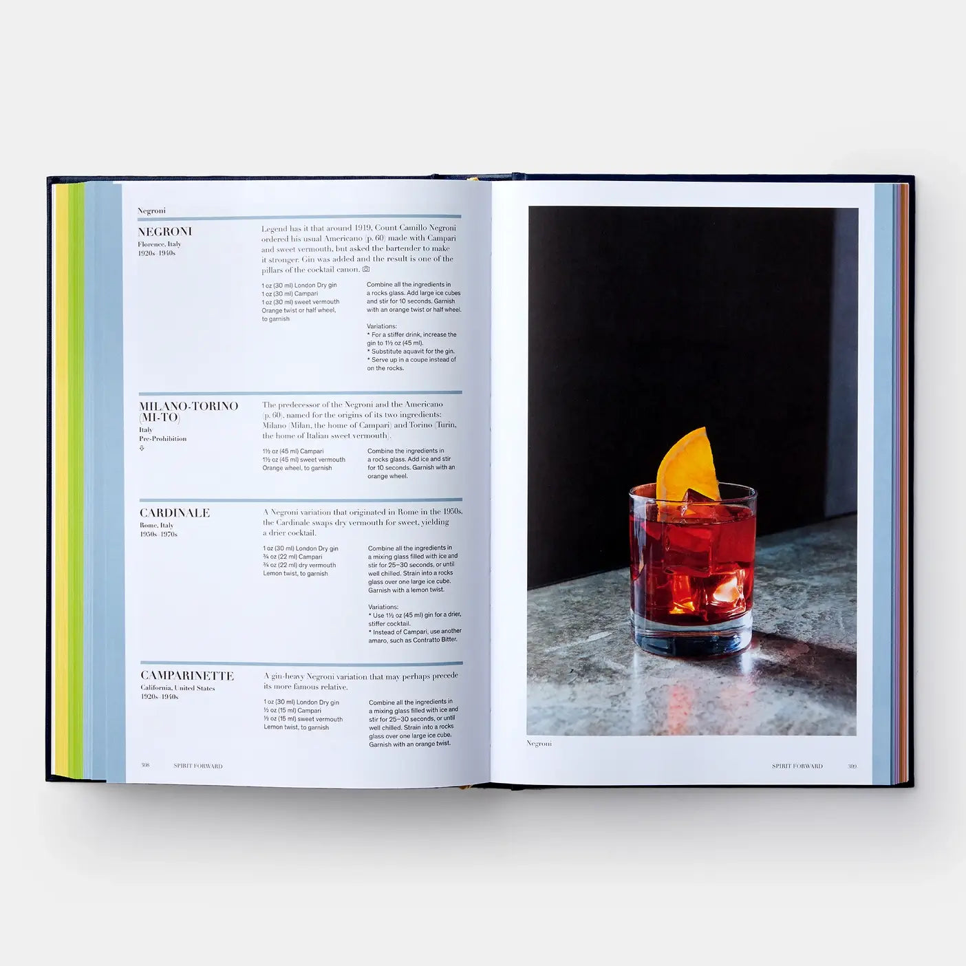 Open book showing a cocktail recipe with a Negroni on a dark surface