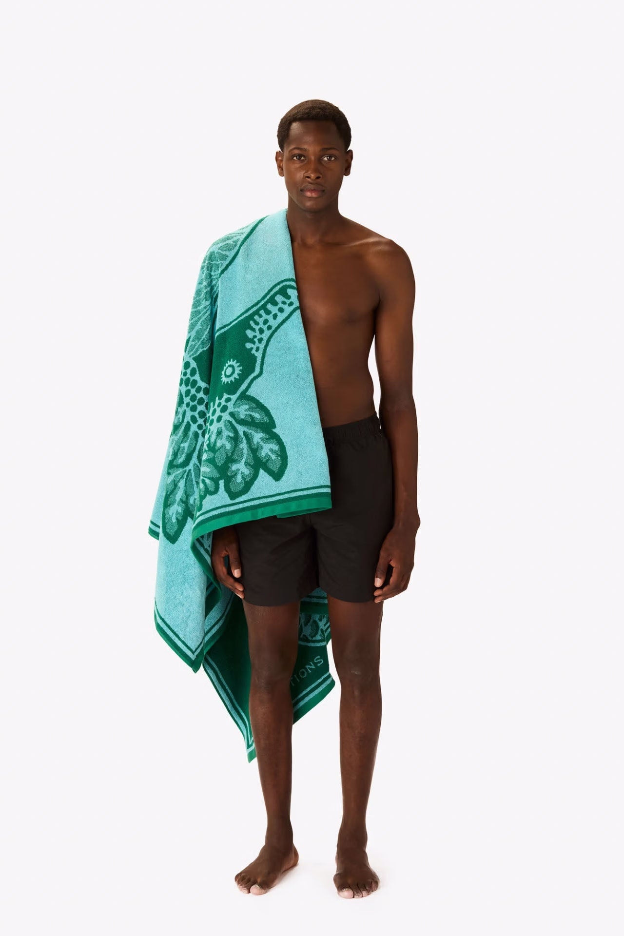 Man holding a turquoise towel with a design on a white background