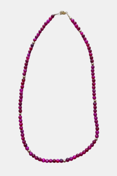 Necklace with pink beads on a marble surface