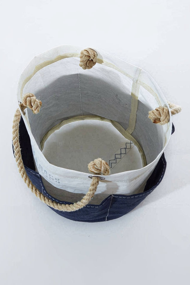 Two buckets, one white and one navy, with rope handles on a light gray background