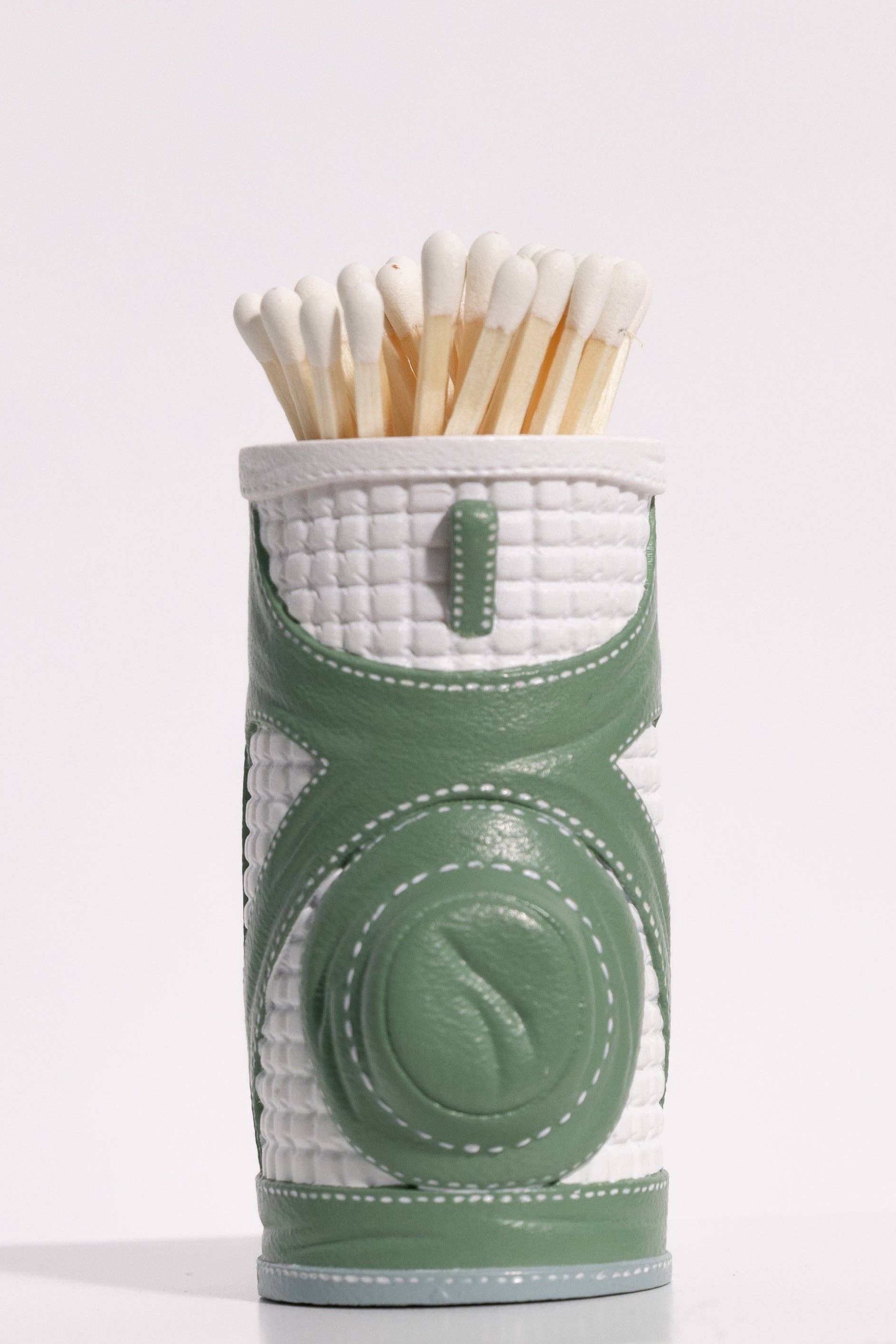 Green and white matchbox with matches on a light gray background