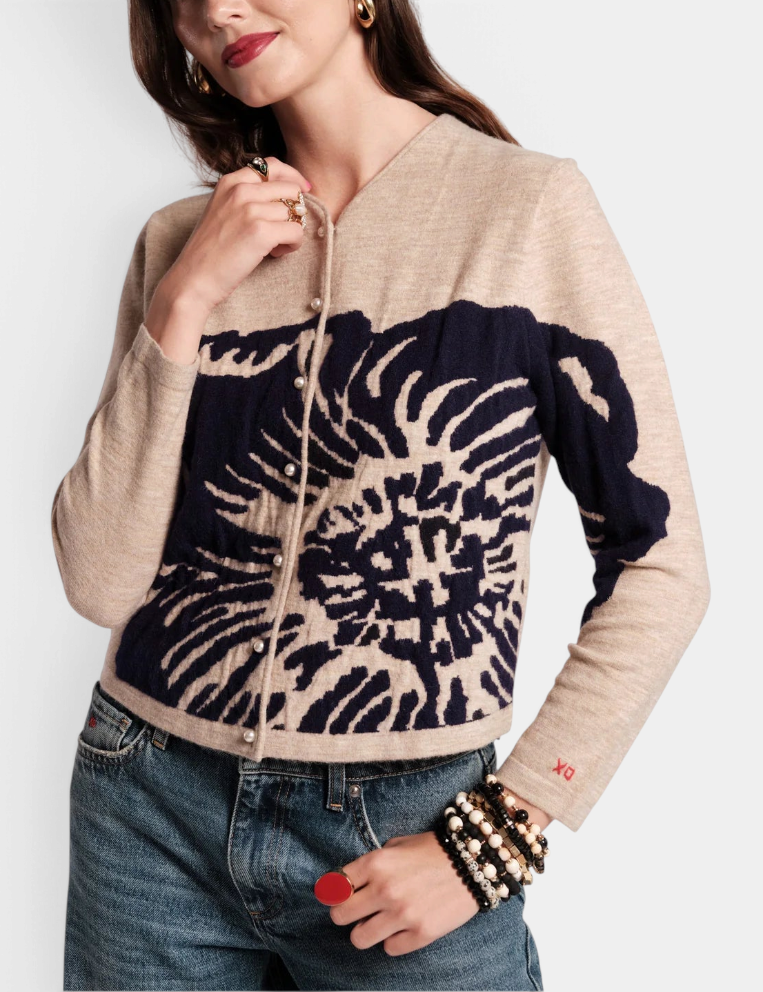 Frances Valentine Darling cardigan in beige merino wool with a navy floral print, pearl buttons, and XO sleeve detail.