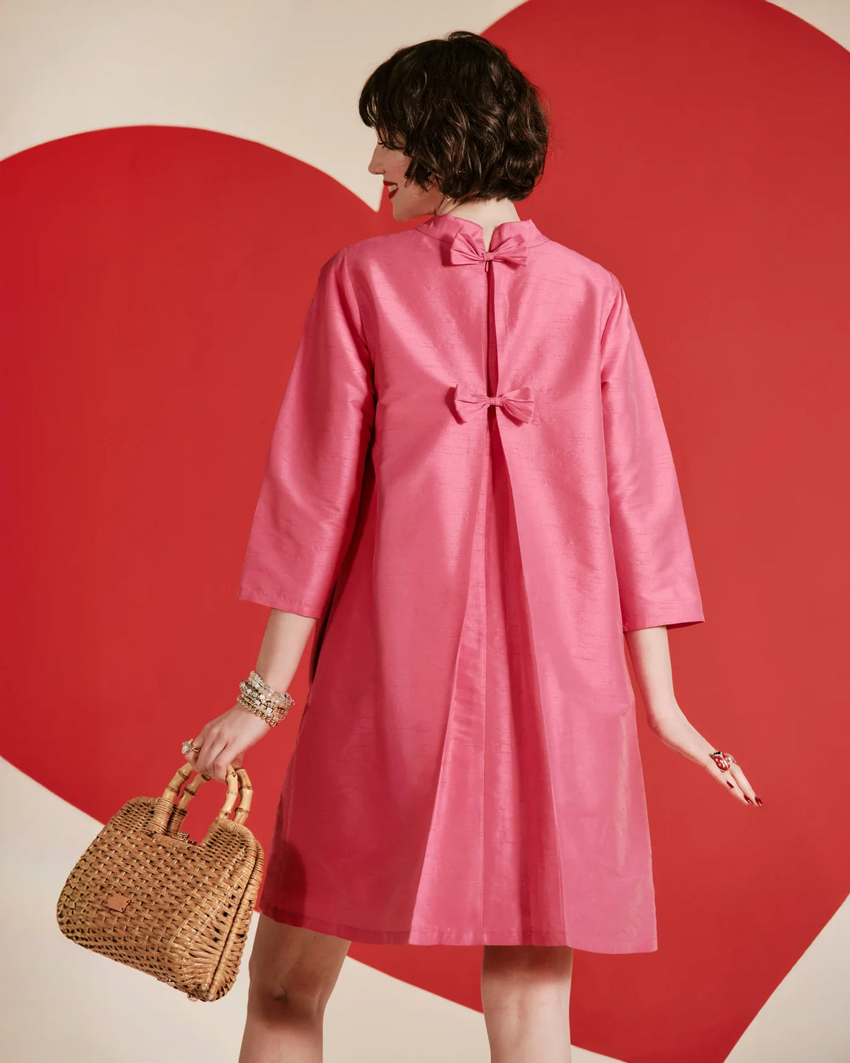 Frances Valentine pink silk A-line dress with high neckline, three-quarter sleeves, and back bow detail on a model.