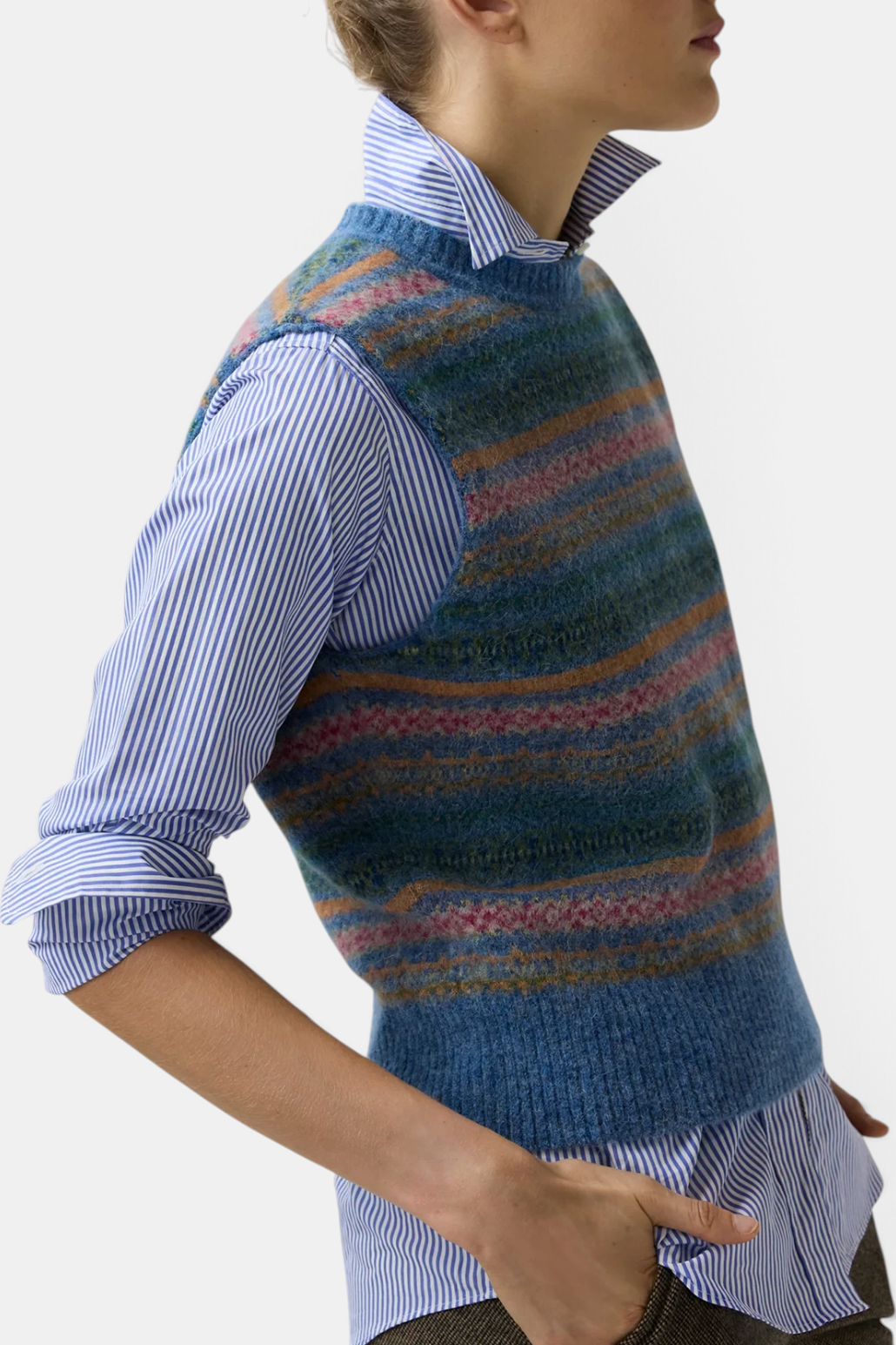 The Copper Shed Silvia Fair Isle sweater vest in blue brushed alpaca wool blend worn over a striped button-down shirt.