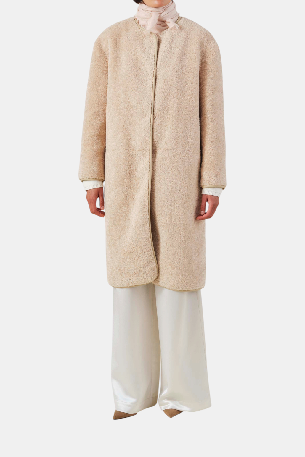The Copper Shed light pink cashmere scarf with herringbone pattern and frayed edges worn around the neck.