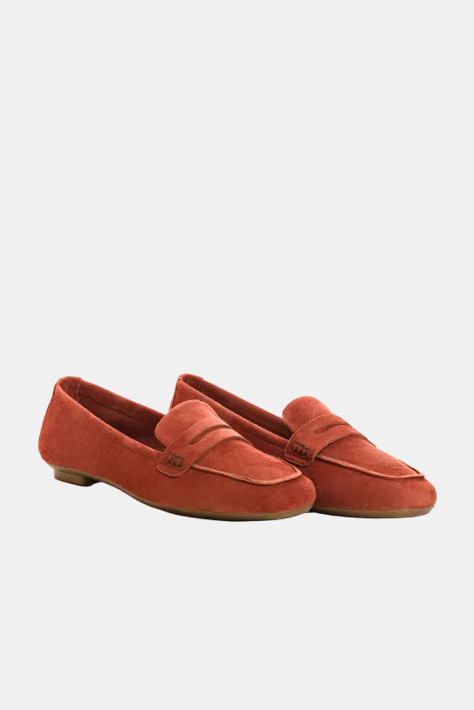 Pair of red loafers on a light beige background