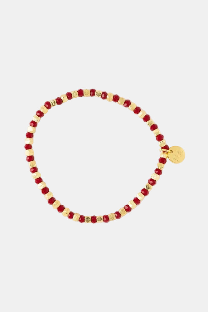 A beaded stretch bracelet featuring alternating deep red faceted beads and small metallic gold spacer beads, with a small round gold charm at the end, displayed on a clean white background.