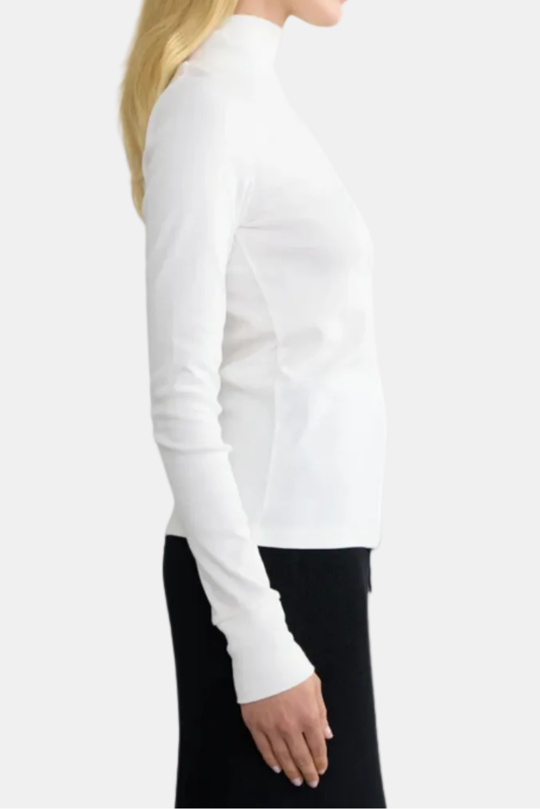 A woman wearing a black long-sleeve turtleneck top with ribbed texture.