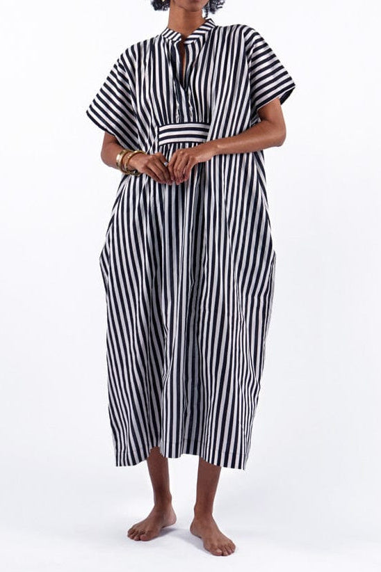 Woman wearing a black and white striped dress on a white background