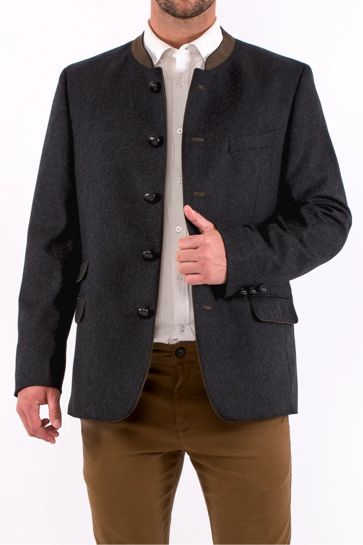 Man wearing a dark gray blazer over a white shirt with brown pants on a white background