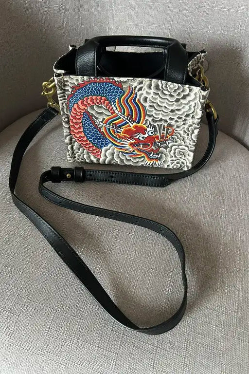 Handbag with dragon design on a textured surface