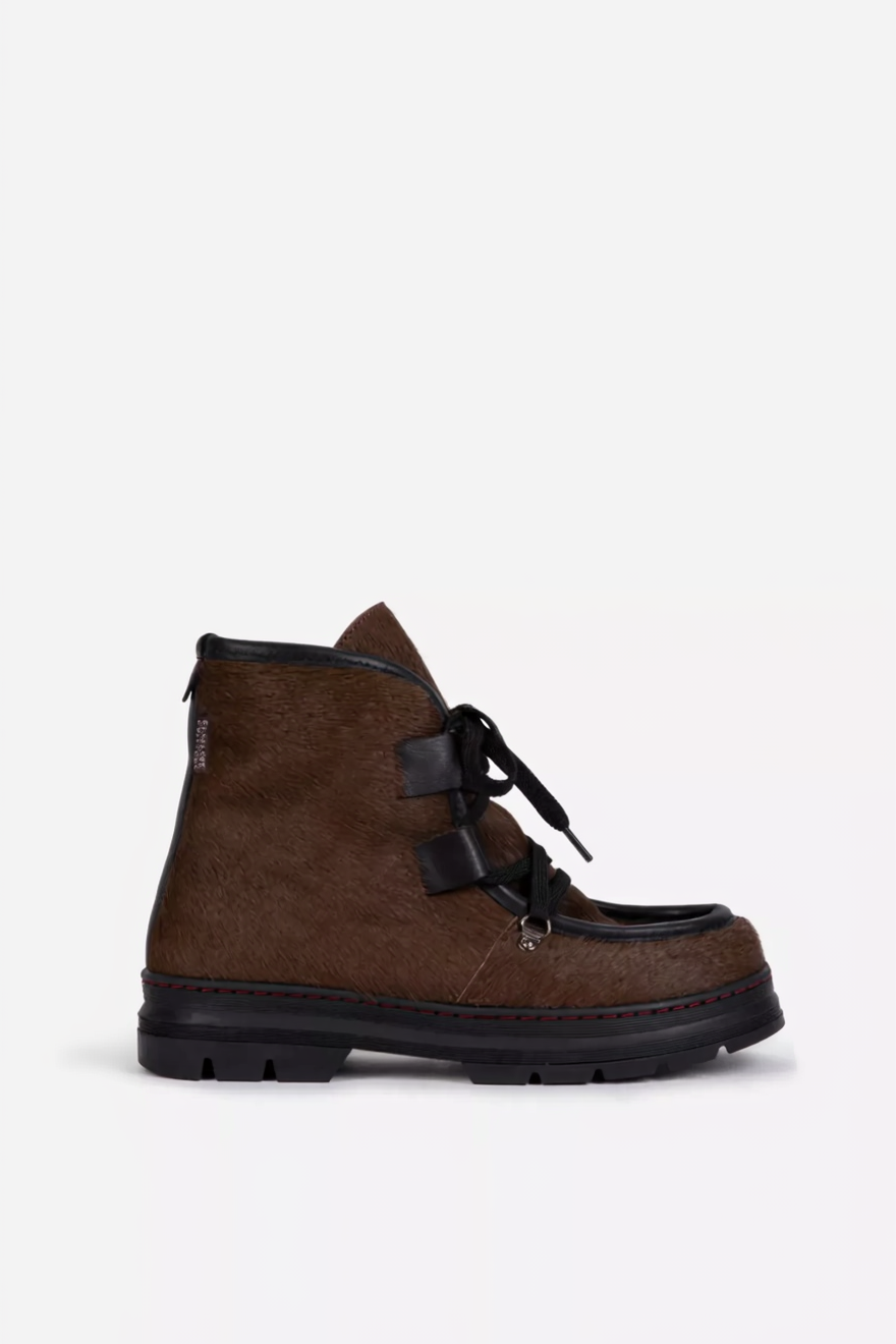 Brown suede boot with black laces on a white background