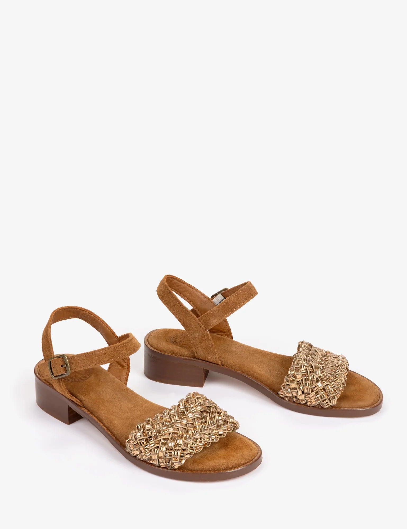 A pair of women's low-heel sandals in tan suede with a textured, woven metallic gold toe strap, shown on a plain white background.