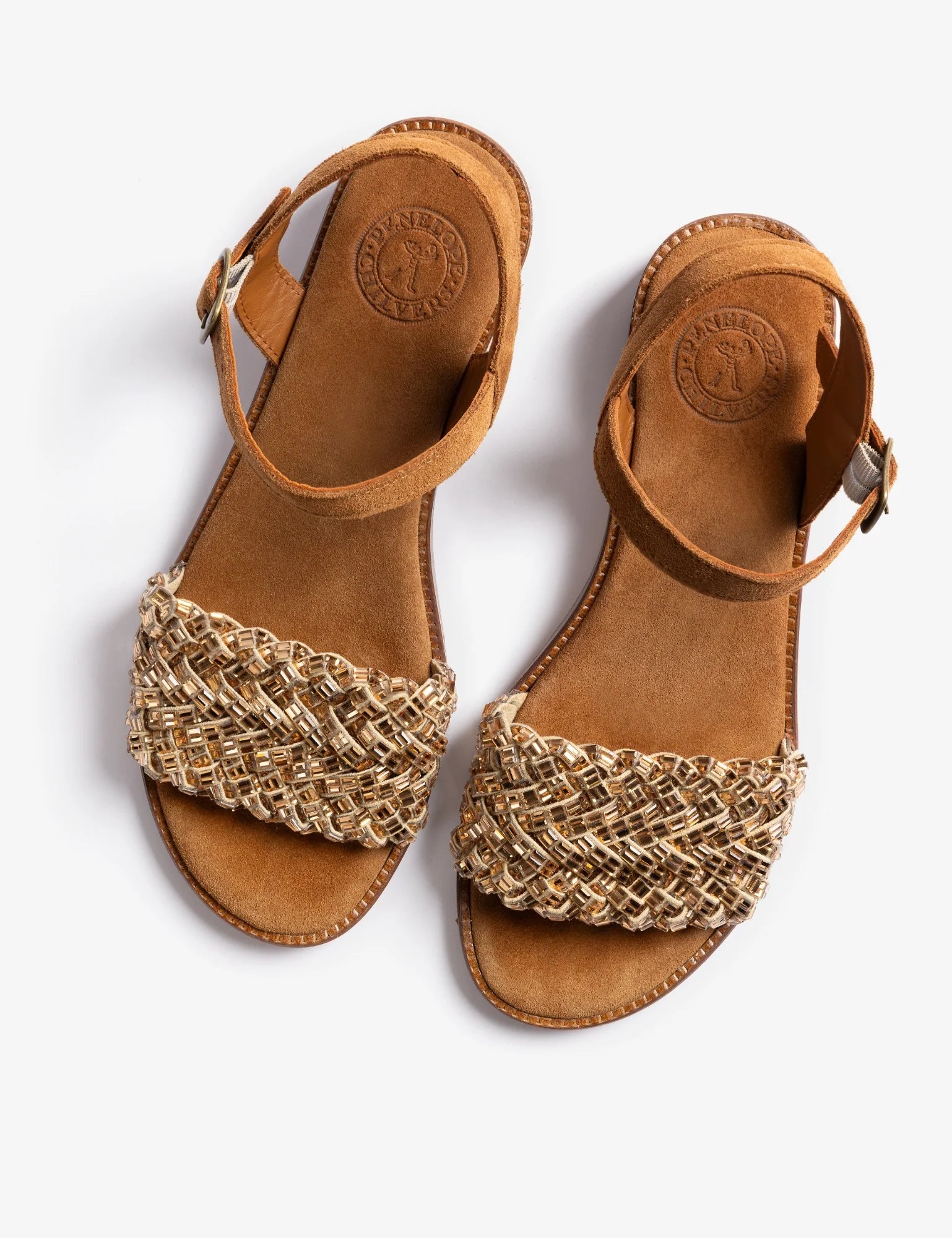 Pair of brown sandals with gold woven straps on a white background