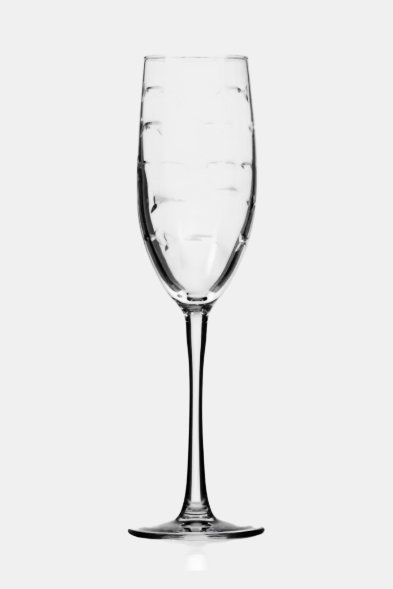 Clear champagne flute with intricate design on a white background
