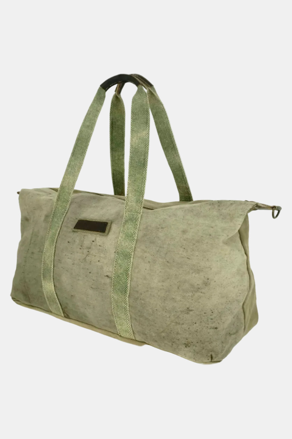 A distressed olive green canvas duffel bag with wide webbing handles, a zippered top, and a small dark brown rectangular patch on the front, shown against a plain white background.