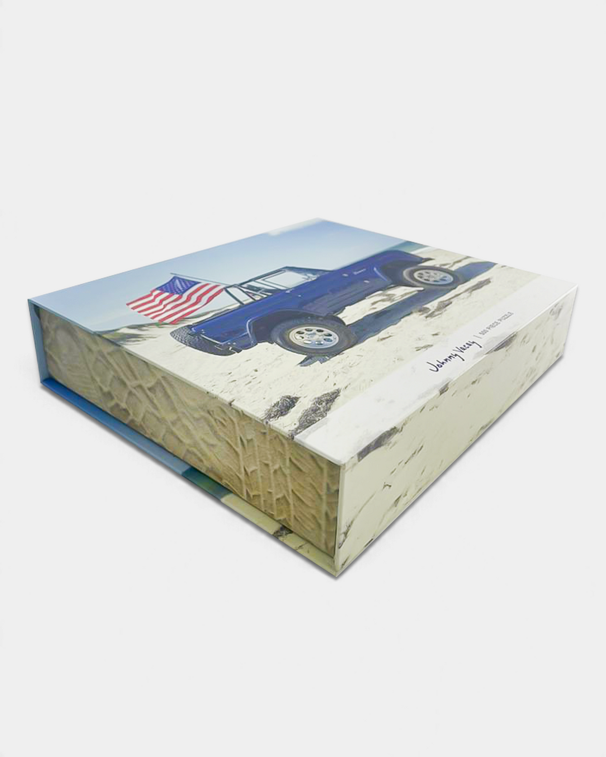 The Copper Shed American Bronco 500 piece puzzle box featuring a blue vintage SUV with an American flag on a beach.